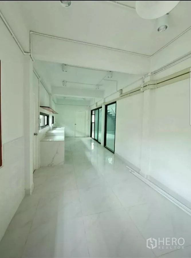 สำนักงานที่บ้าน ให้เช่าในLat Phrao, Bangkok - แพนทรีครัวรูปทรงยาว เคาน์เตอร์สีขาว เปิดสู่ลานบ้านด้วยประตูกระจก