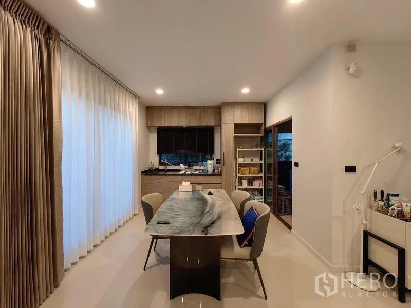 独立式住宅 出租在Bang Kapi, Bangkok - 餐区配大理石桌，旁连茶水吧与全高窗帘