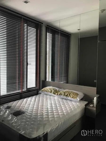 公寓 出租在Watthana, Bangkok - 卧室配平台床、镜面衣柜与带百叶的大窗，采光充足。