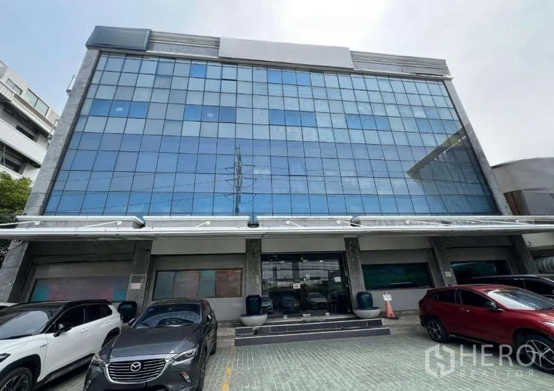 Office Space for rent - Modern glass-fronted office building with ample parking at the front.