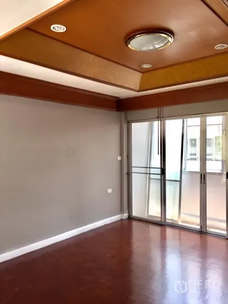 ทาวน์เฮาส์ ให้เช่าในWatthana, Bangkok - ห้องนั่งเล่นสว่าง พื้นปาร์เกต์ ฝ้าเพดานหลุม พร้อมประตูกระจกบานเลื่อนออกสู่ระเบียง