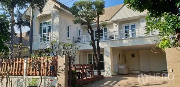 独立式住宅 出租在Phra Khanong, Bangkok - 两层独栋别墅外观，设阳台、车棚、木栅栏与成树。