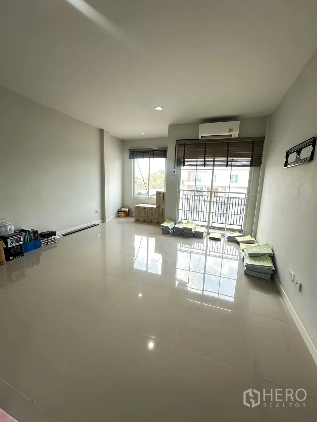 Home Office for rent in Khlong Luang, Pathum Thani - Another angle of the light-filled open room with stacks of documents and balcony access.