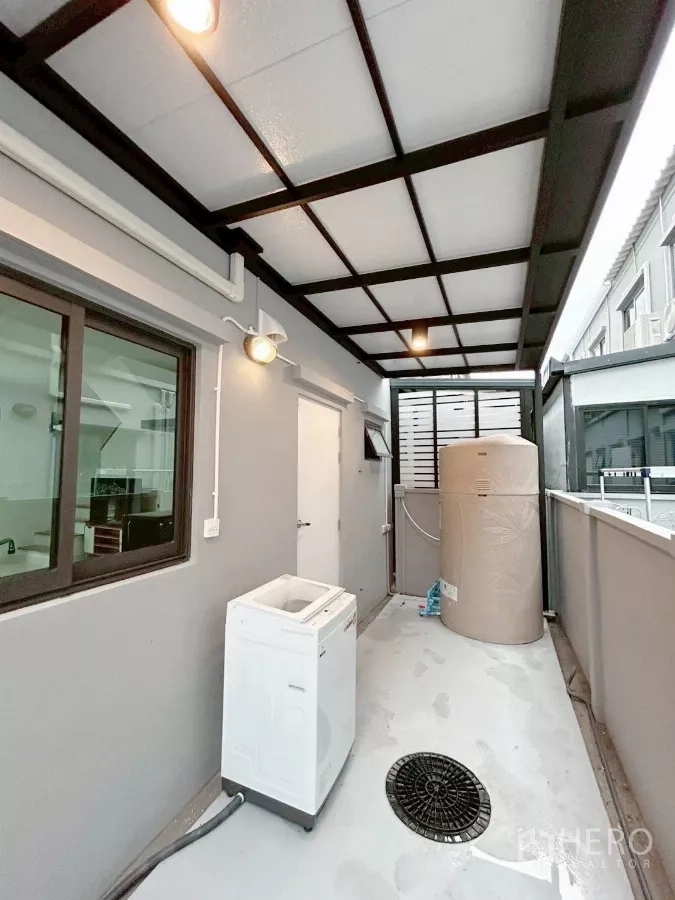 ทาวน์เฮาส์ ให้เช่าในBang Phli, Samut Prakan - มุมมองกว้างของลานซักล้างมีหลังคา พร้อมถังเก็บน้ำและไฟส่องสว่าง