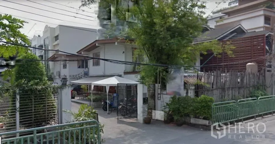 零售空间 出租在Watthana, Bangkok - 素坤逸31区低层临街建筑外观，带大门与绿植，周边为住宅区。