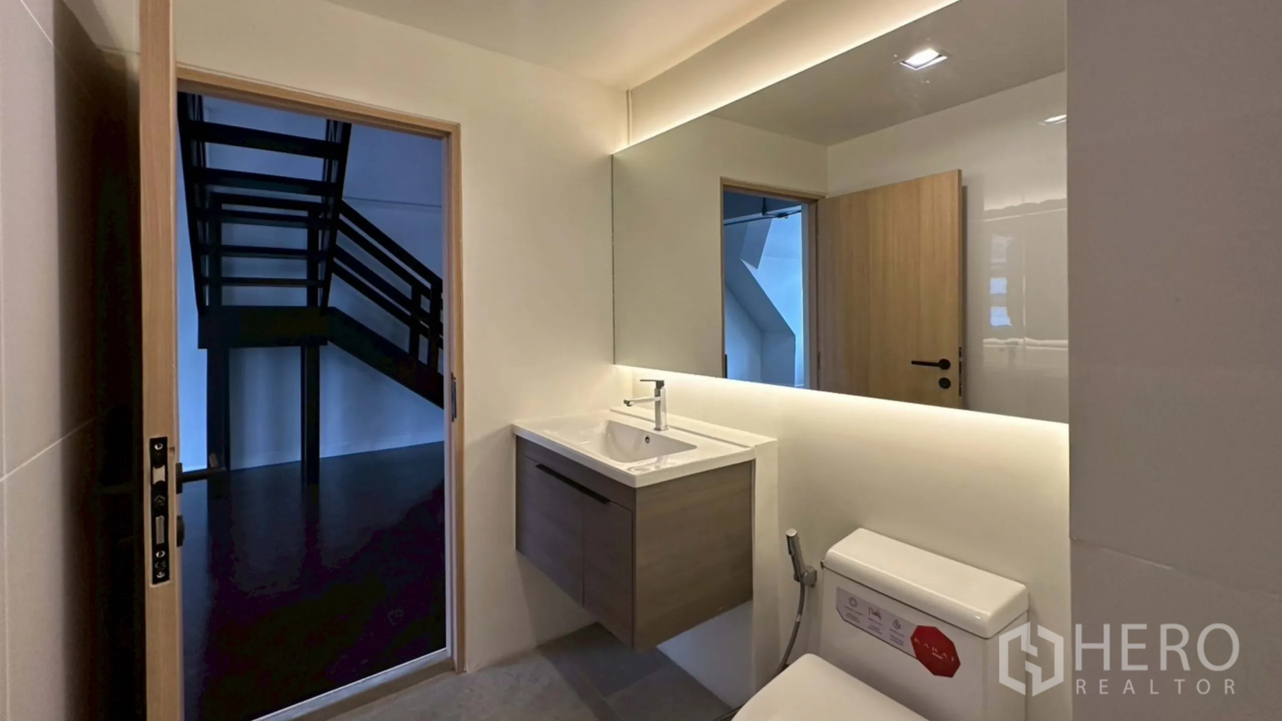 Home Office for rent in Watthana, Bangkok - Bathroom with floating vanity and view toward the staircase through doorway.
