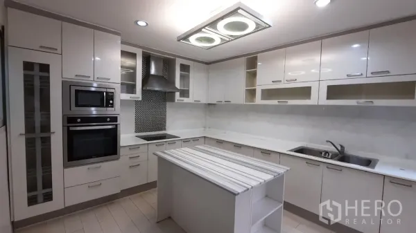 Townhouse for sale in Suan Luang, Bangkok - Full view of U-shaped kitchen with hob, hood and central island