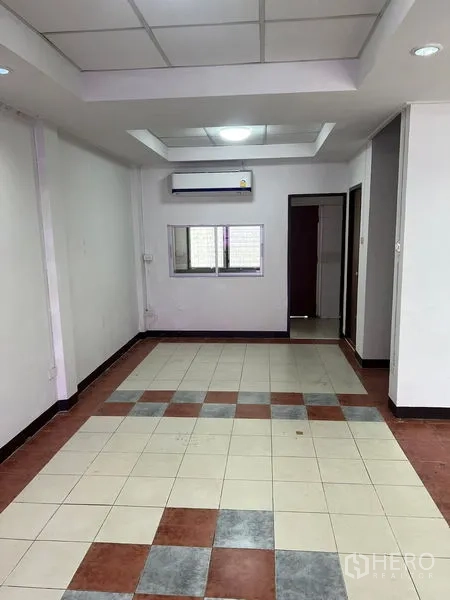 Townhouse for rent in Khlong Toei, Bangkok - Long living space with recessed ceiling, tiled floor and air conditioning.