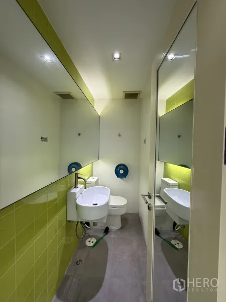 零售空间 出租在Bang Rak, Bangkok - 私密卫生间，绿色点缀墙砖、长镜与白色洁具