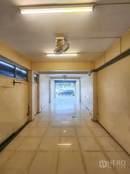 店屋 出租在Bang Rak, Bangkok - 一层商铺空间，地面铺砖，顶灯照明，玻璃门面临街