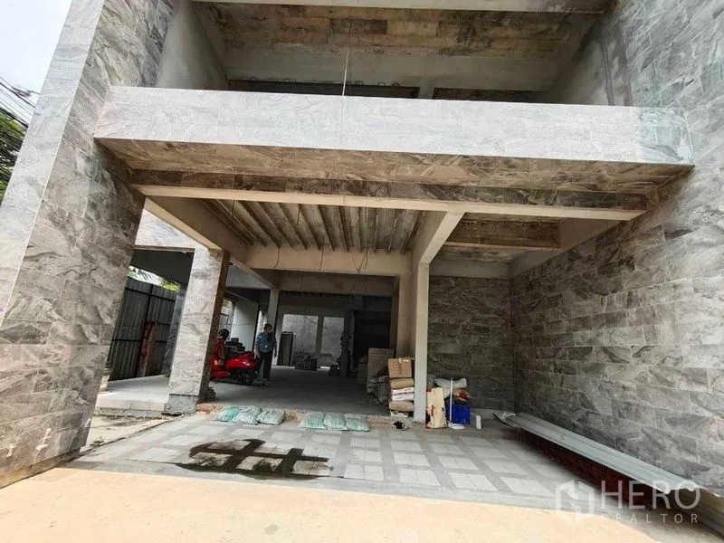 Home Office for rent in Watthana, Bangkok - Covered ground-level entry and parking bay framed by stone walls at a home office building.