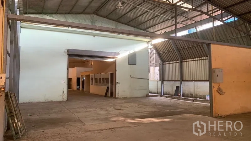Warehouse for rent in Mueang Nakhon Pathom, Nakhon Pathom - Covered loading area with sloped metal roof and access to an internal office section.