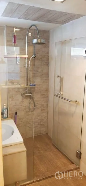 公寓 出售在Watthana, Bangkok - 浴室设玻璃淋浴间与顶喷花洒，米色墙砖。