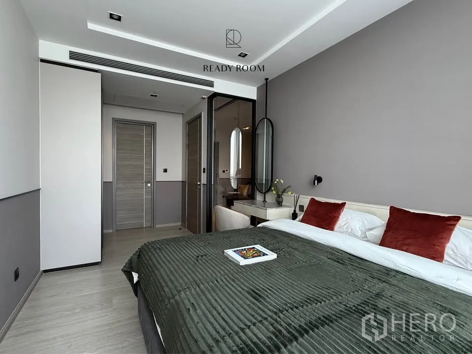 คอนโด for rent in Khlong Toei, Bangkok - ห้องนอนสไตล์โมเดิร์น เตียงใหญ่ หมอนส้ม โต๊ะเครื่องแป้ง และฉากกั้นกระจก