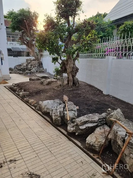 บ้าน ให้เช่าหรือขายในSathon, Bangkok - สวนดูแลง่ายด้วยโขดหินและต้นไม้ตัดแต่งข้างรั้วยามเย็น