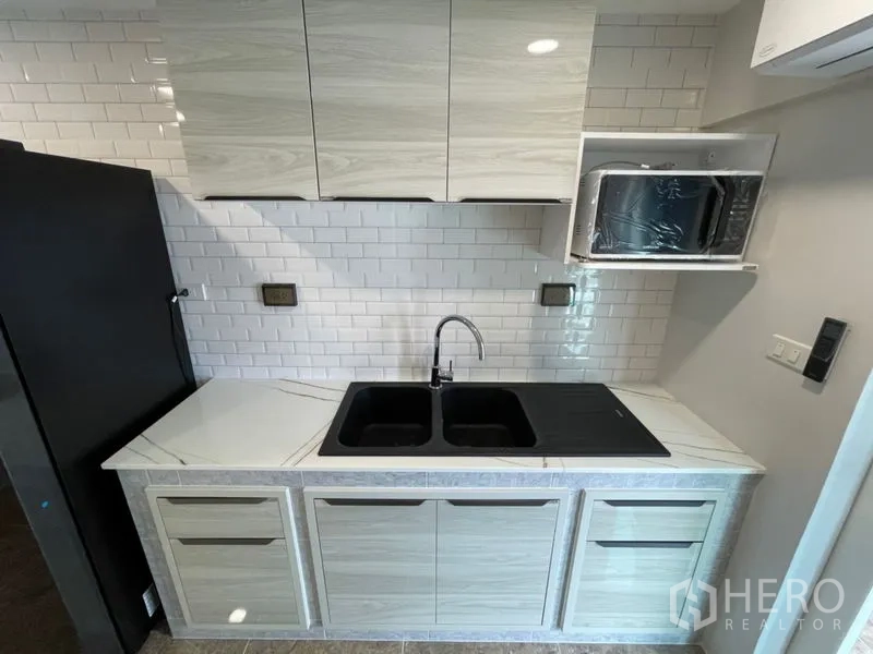 คอนโด ให้เช่าหรือขายในWatthana, Bangkok - แพนทรีขนาดกะทัดรัด พร้อมอ่างล้างจานคู่ เตาอินดักชัน และตู้เก็บของเหนือศีรษะ