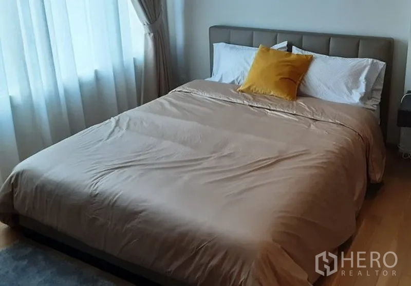 คอนโด ให้เช่าในKhlong Toei, Bangkok - ห้องนอนอบอุ่น เตียงคู่ หัวเตียงบุนวม ชุดเครื่องนอนสีเบจ และหน้าต่างใหญ่พร้อมผ้าม่าน