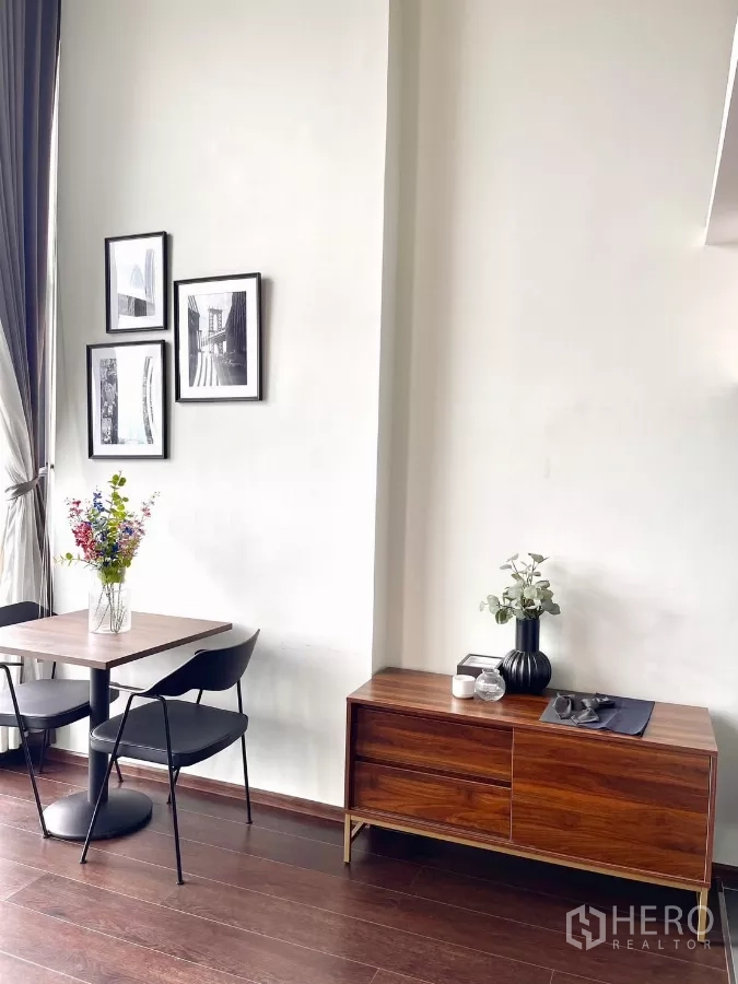 Condominium for rent in Watthana, Bangkok - Dining corner by a full-height window with wooden cabinet and vase.