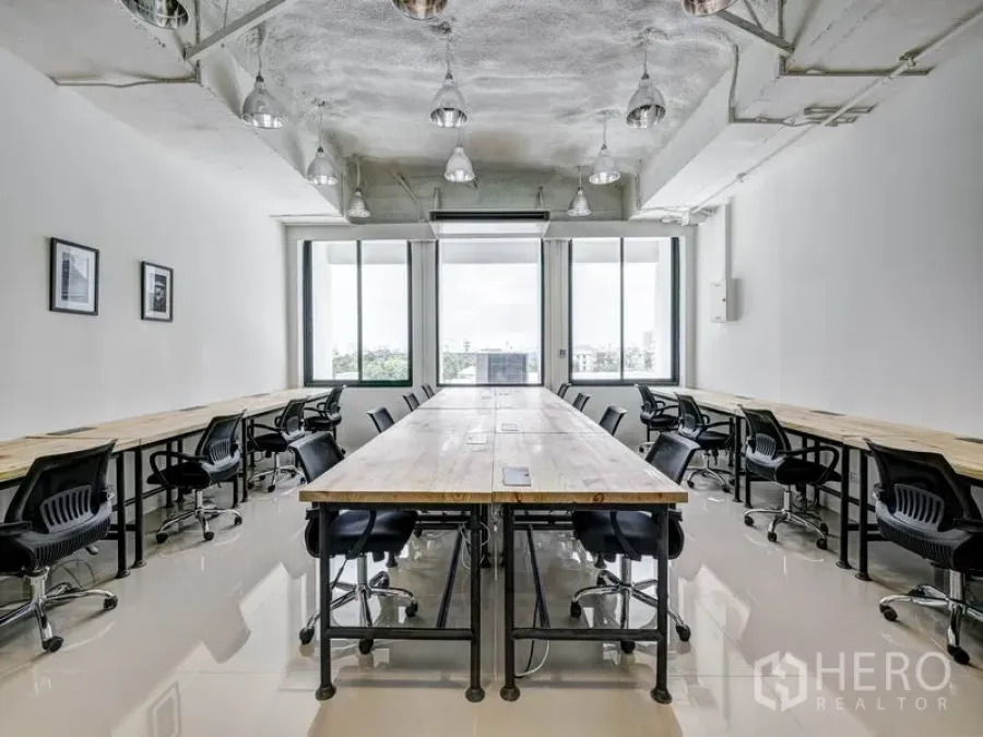 Office Space for rent in Khlong Toei, Bangkok - Bright serviced office with long wooden desks, ergonomic black chairs, large windows and industrial pendant lights.