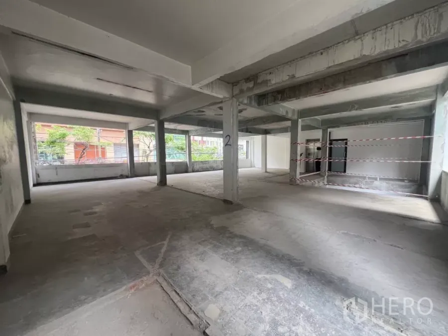 零售空间 出租在Bang Rak, Bangkok - 二楼开放式零售毛坯空间，混凝土地面、承重柱与临街大窗采光充足。