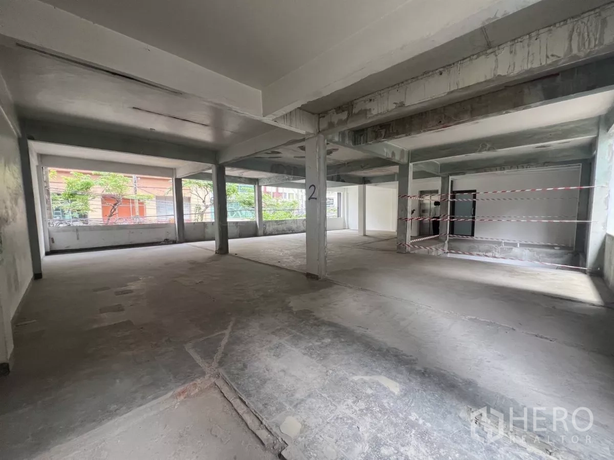 零售空间 出租在Bang Rak, Bangkok - 二楼开放式零售毛坯空间，混凝土地面、承重柱与临街大窗采光充足。