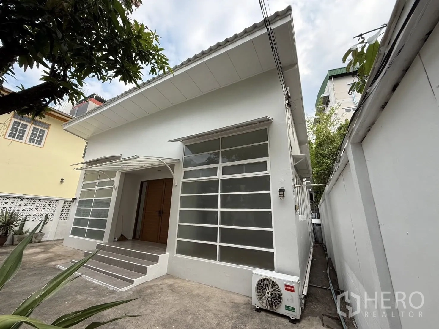 บ้านเดี่ยว for rent in Khlong Toei, Bangkok - มุมด้านข้างบ้านชั้นเดียว บันไดทางเข้าพร้อมกันสาดและเครื่องปรับอากาศภายนอก