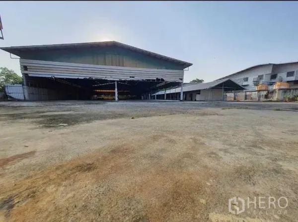 货栈 出租或出售在Mueang Pathum Thani, Pathum Thani - 大型金属外墙仓库正面，前方为宽大装卸与回车场地。