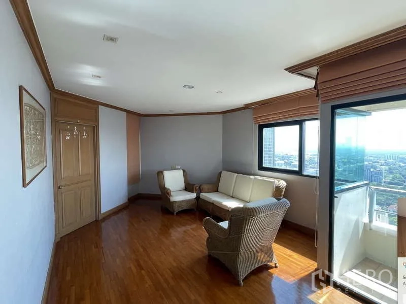 คอนโด ให้เช่า - มุมนั่งเล่นสบาย เก้าอี้หวายข้างระเบียง มองเห็นวิวเมือง