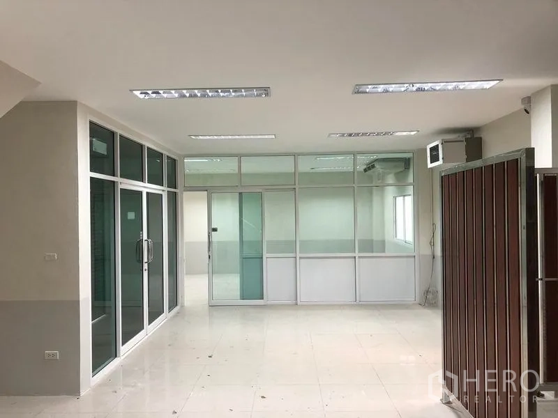 Factory for rent in Samut Prakan - Ground-floor office beside the factory with glass partitions, sliding doors and tiled flooring.