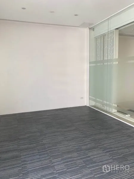 Office Space for rent in Khlong Toei, Bangkok - Carpeted private room enclosed by a clear glass sliding wall.