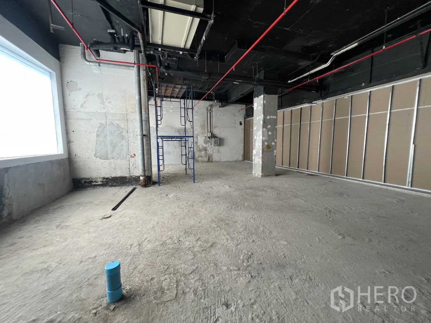 Retail Space for rent in Pathum Wan, Bangkok - Open-plan shell space with a large window and framed partition wall.