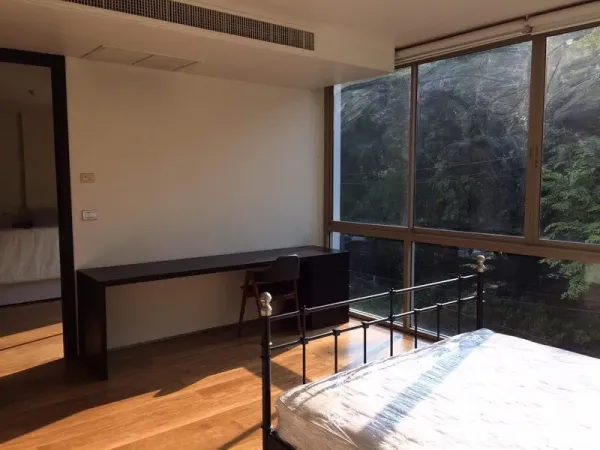 คอนโด ให้เช่าในKhlong Toei, Bangkok - มุมทำงานในห้องนอน โต๊ะยาว เตียงเหล็ก และหน้าต่างกว้างวิวต้นไม้