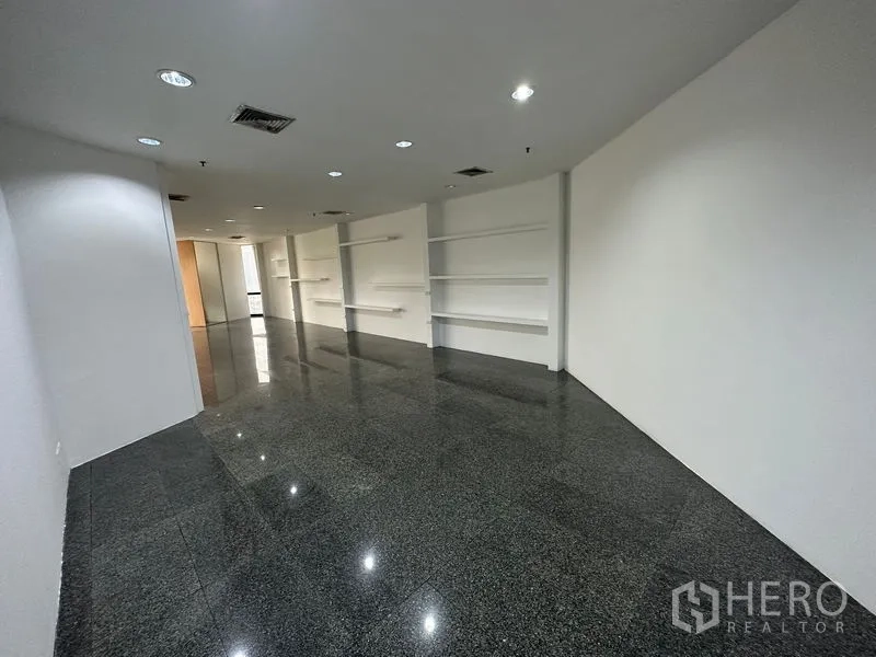 办公空间 出租 - 宽敞开放式办公区，筒灯照明，内置墙面搁架与镜面地面。