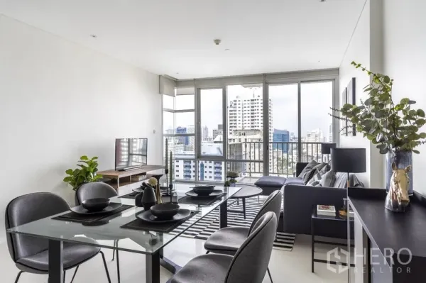 公寓 出租在Watthana, Bangkok - 玻璃餐桌置于整面落地窗旁，俯瞰城市景色。