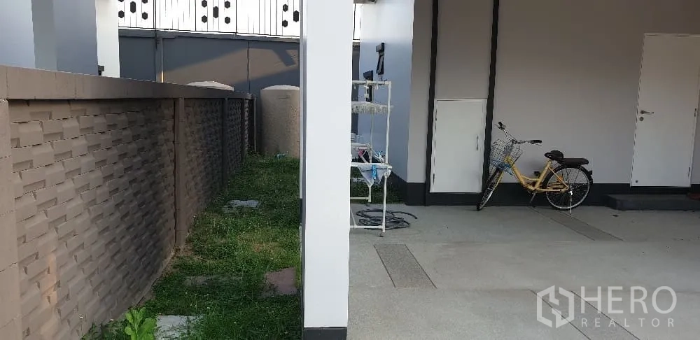 บ้าน ให้เช่าหรือขายในLam Luk Ka, Pathum Thani - ลานข้างบ้านและโรงจอดรถมีประตูเก็บของและจักรยาน