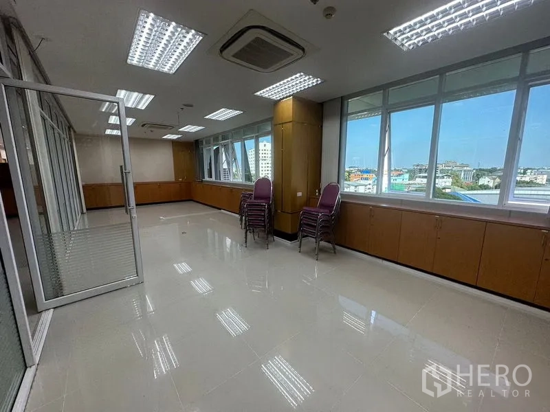 Office Space for rent in Suan Luang, Bangkok - Corner office with full-length windows, cassette air-conditioning and low built-in cabinetry.