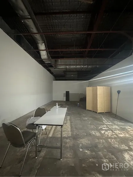 พื้นที่ขายปลีก ให้เช่า - ภายในแปลนโล่งลึก เพดานสูงแบบเปิดโชว์งานระบบ และพื้นยังไม่ปูเสร็จ