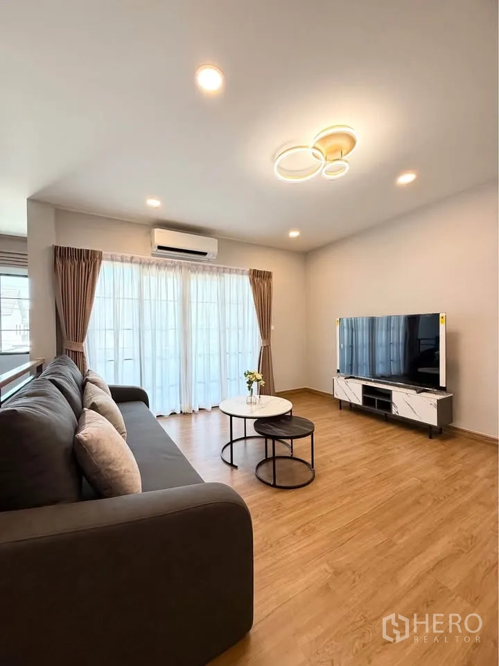 Detached House for rent in Bang Phli, Samut Prakan - Upstairs family lounge with sofa, coffee tables, TV, and balcony doors.