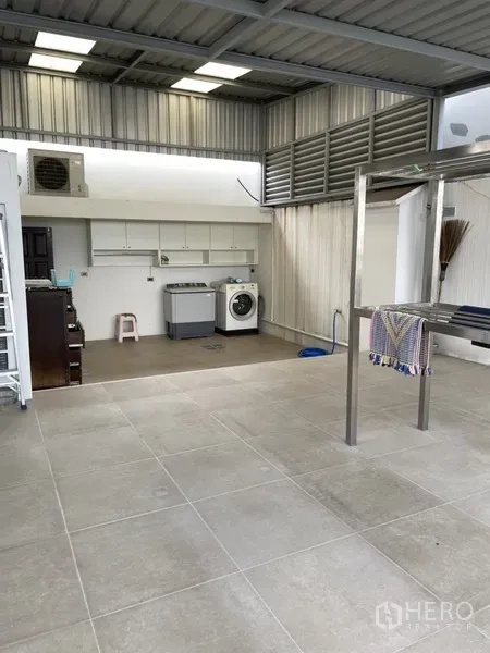 Home Office for rent or sale in Phra Khanong, Bangkok - Covered utility area with tiled floor, metal roof, cabinets and a washing machine.