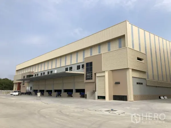 工厂 出租或出售在Samut Prakan - 现代化工厂外观，设多组月台装卸位、雨棚与宽阔混凝土场地。