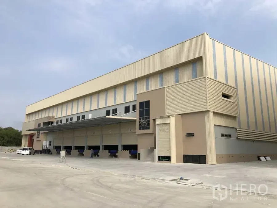 工厂 出租或出售在Samut Prakan - 现代化工厂外观，设多组月台装卸位、雨棚与宽阔混凝土场地。