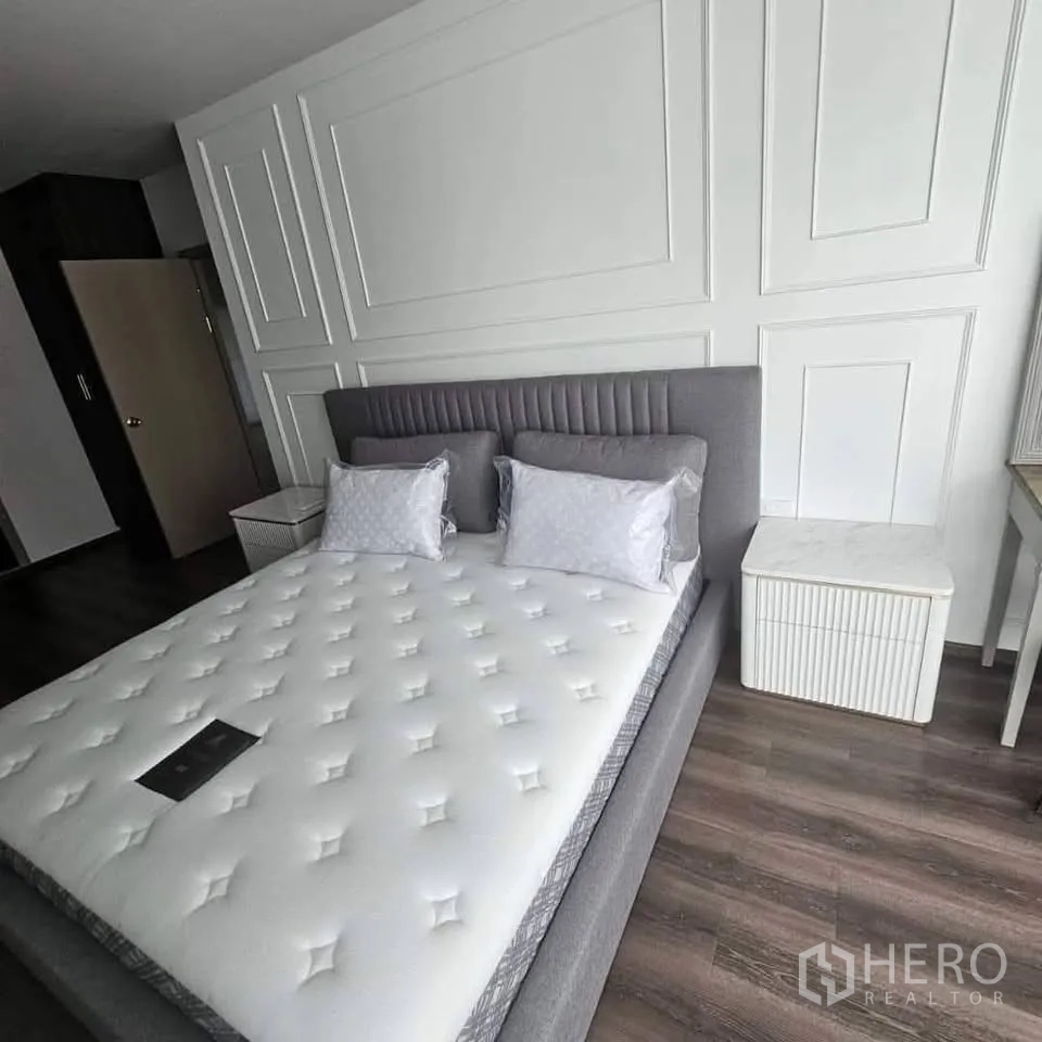 公寓 for rent in Huai Khwang, Bangkok - 卧室配灰色软包床、线条墙面与成对床头柜。