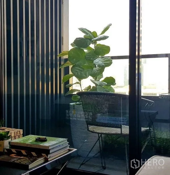 公寓 出售在Bang Rak, Bangkok - 私人阳台，盆栽与户外椅，推拉玻璃门相连。