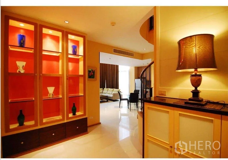 คอนโด ให้เช่า - โถงทางเข้าบรรยากาศอบอุ่น ตู้โชว์ไฟในตัว บันไดเวียน และโคมไฟ นำสู่พื้นที่นั่งเล่น