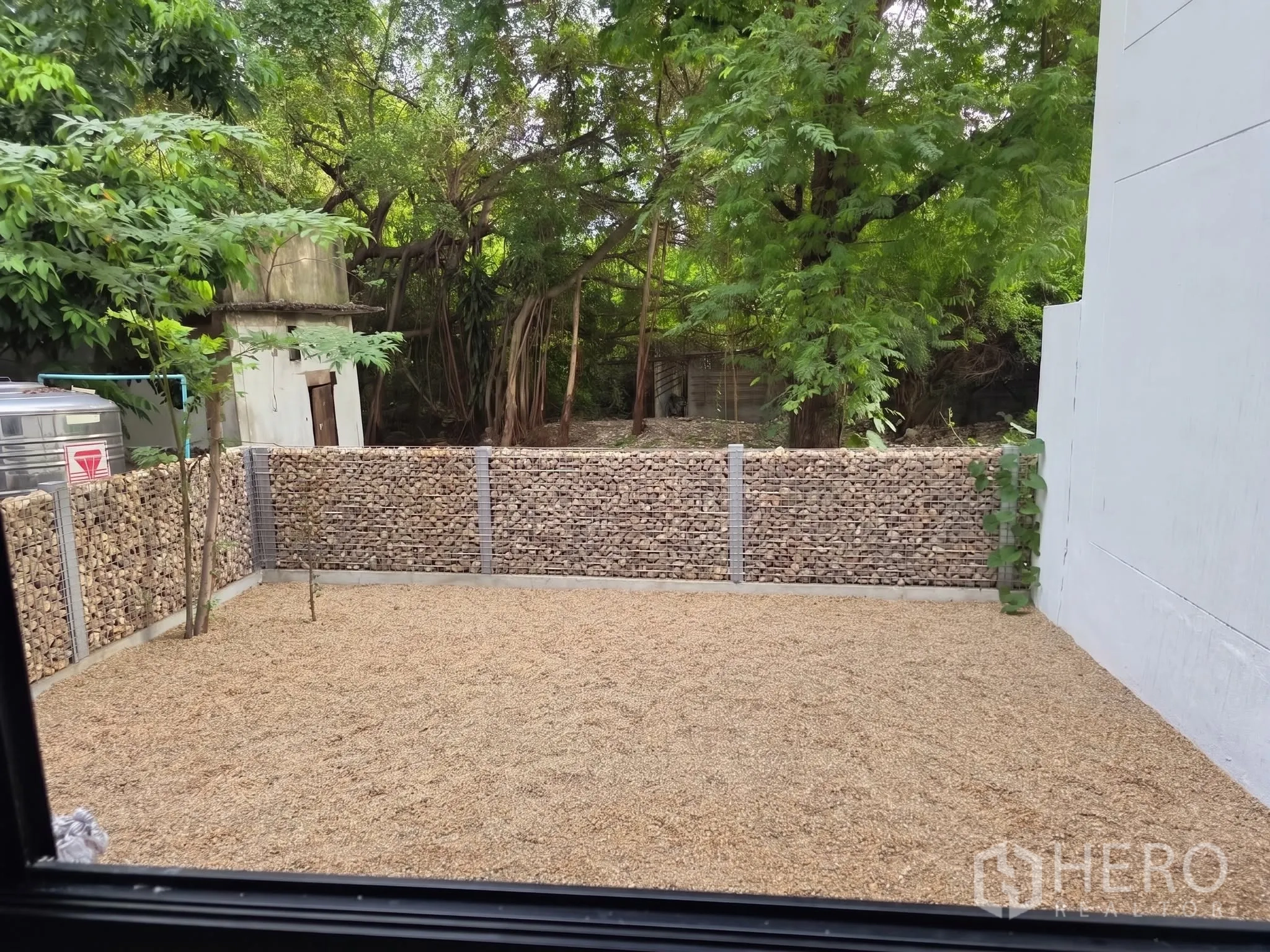 โฮมออฟฟิศ for rent or sale in Phra Khanong, Bangkok - ลานหลังบ้านโรยหินพร้อมรั้วตะแกรงหินและต้นไม้ใหญ่.