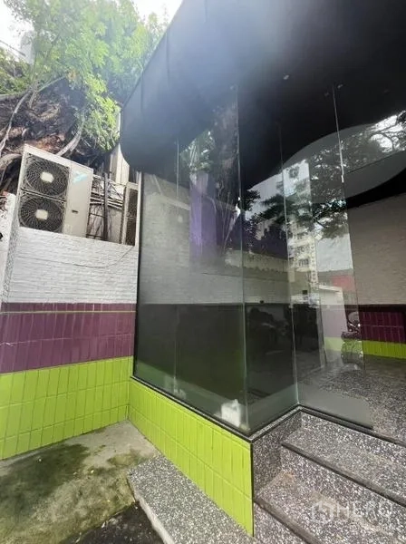 พื้นที่ขายปลีก ให้เช่าในWatthana, Bangkok - มุมด้านข้างกระจกสูงโปร่ง ฐานกรุไทล์สีเขียว‑ม่วง และขั้นบันได