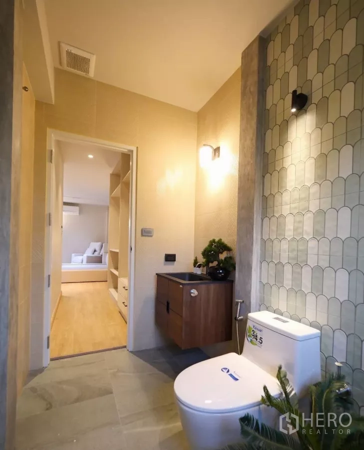 ทาวน์เฮาส์ ให้เช่าในWatthana, Bangkok - ห้องน้ำปูกระเบื้องลายเรขาคณิต อ่างล้างหน้าแขวนผนัง และโถสุขภัณฑ์