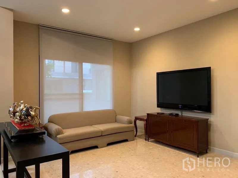 บ้าน ให้เช่าหรือขายในKhan Na Yao, Bangkok - ห้องดูทีวีอบอุ่น ทีวีติดผนัง โซฟา และตู้วางของ