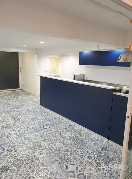 零售空间 出租在Bang Rak, Bangkok - 店内海军蓝服务吧台与白色地铁砖背景墙。