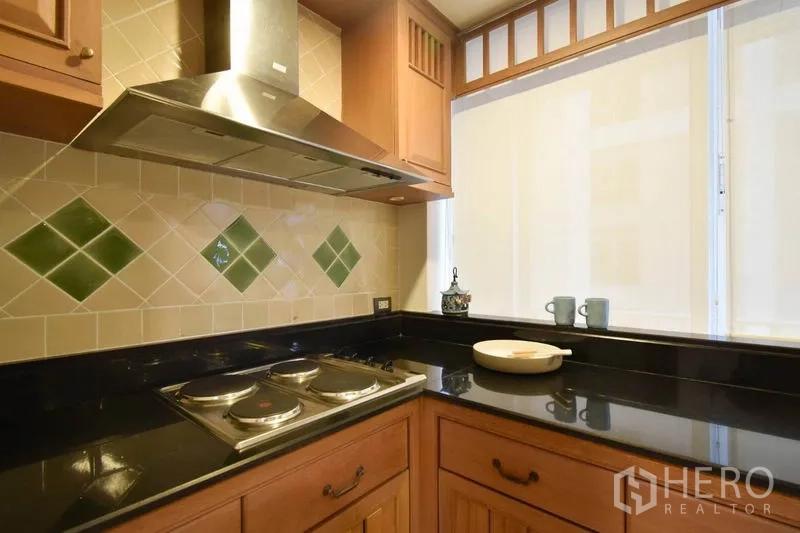 คอนโด ให้เช่าในPathum Wan, Bangkok - ครัวปิด เตาไฟฟ้า เครื่องดูดควัน เคาน์เตอร์หินแกรนิต และผนังกระเบื้อง